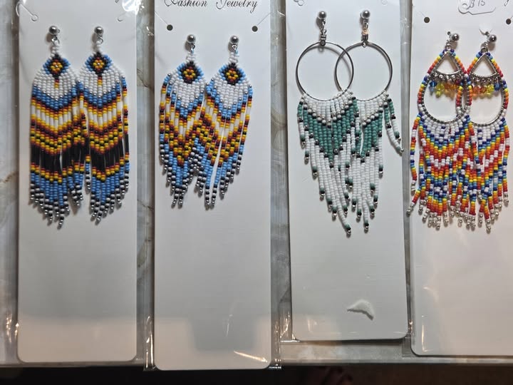 Assorted colorful handmade beaded earrings displayed on cards